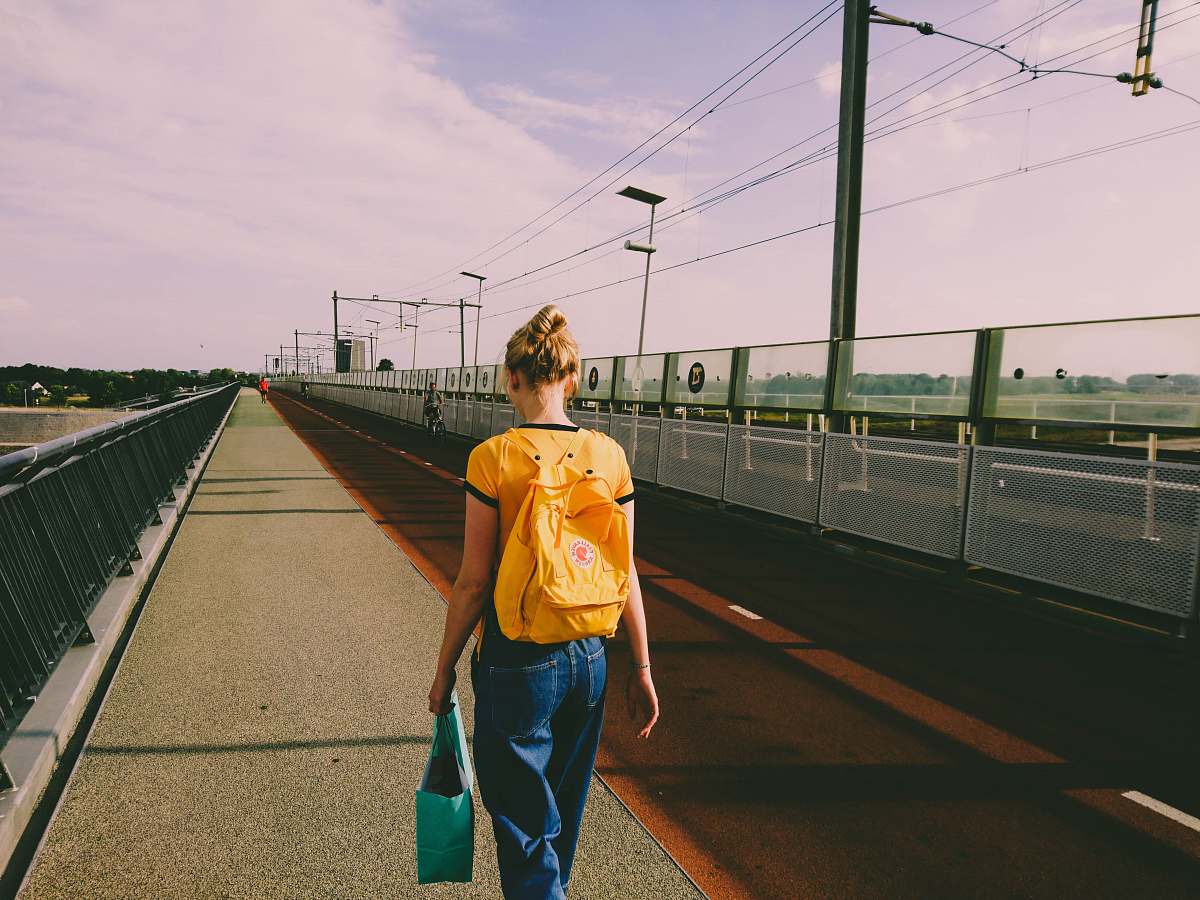 people woman in yellow walking on street person