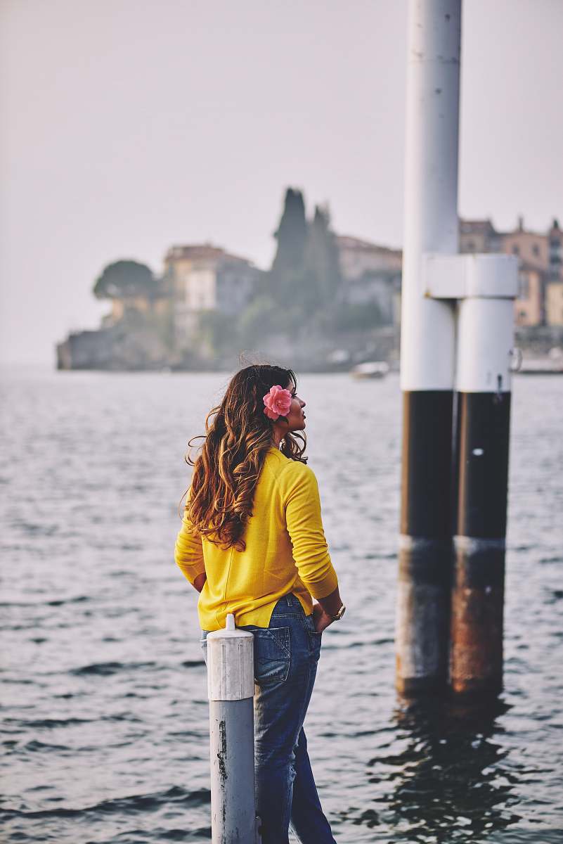 people woman leaning against on gray wooden pole person