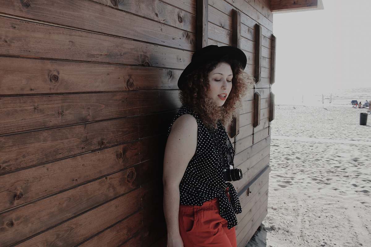 people woman leaning on brown wooden wall outdoors person
