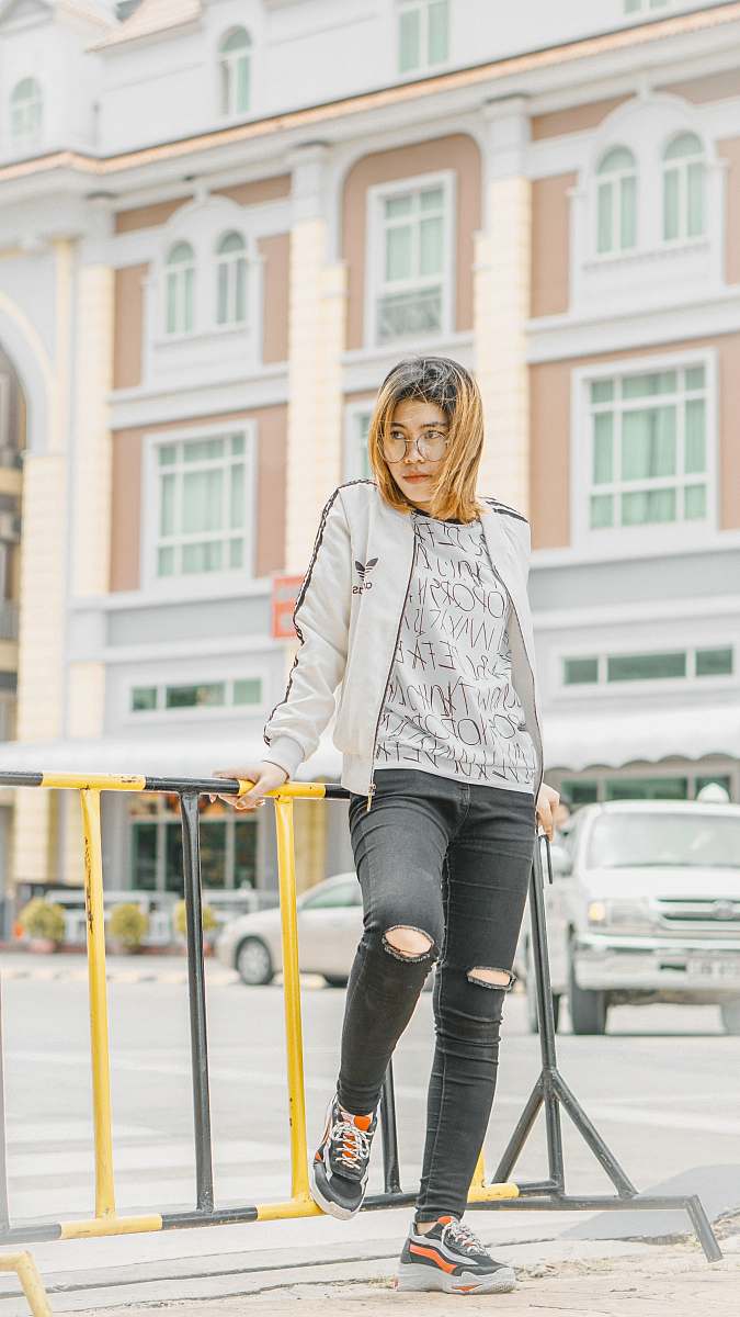 people woman leaning on metal handrail front of building at daytime person