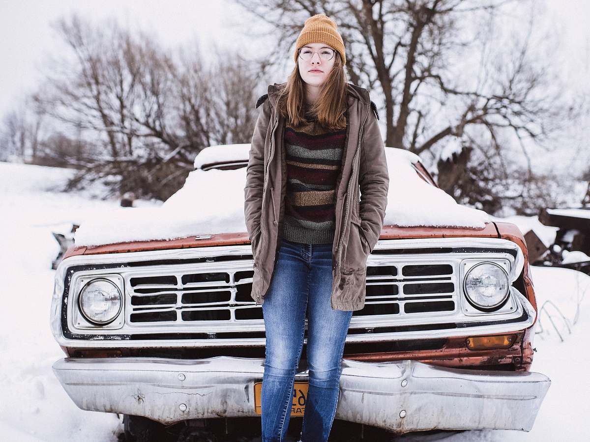 person woman leaning on snow covered car people