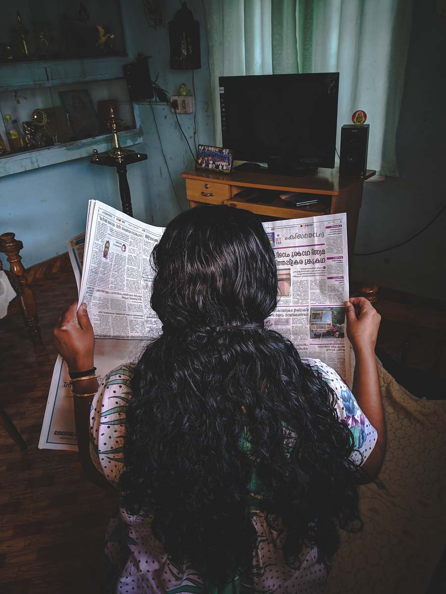 people woman reading newspaper person