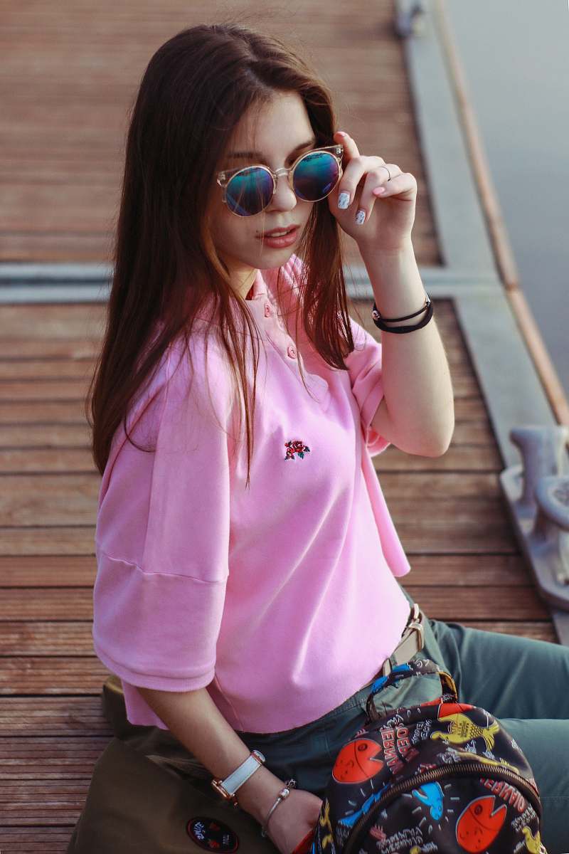 people woman sitting at the dock holding her sunglasses person