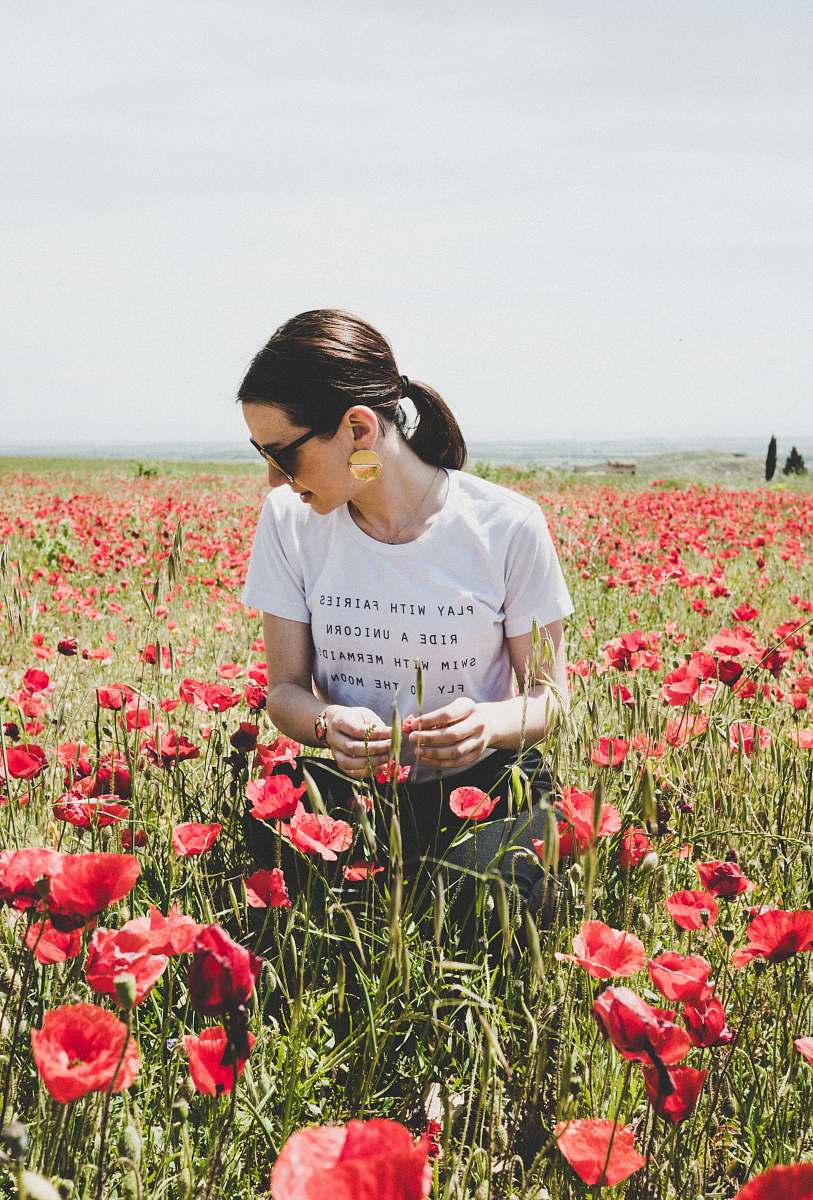 flower woman sitting on common poppy field poppy