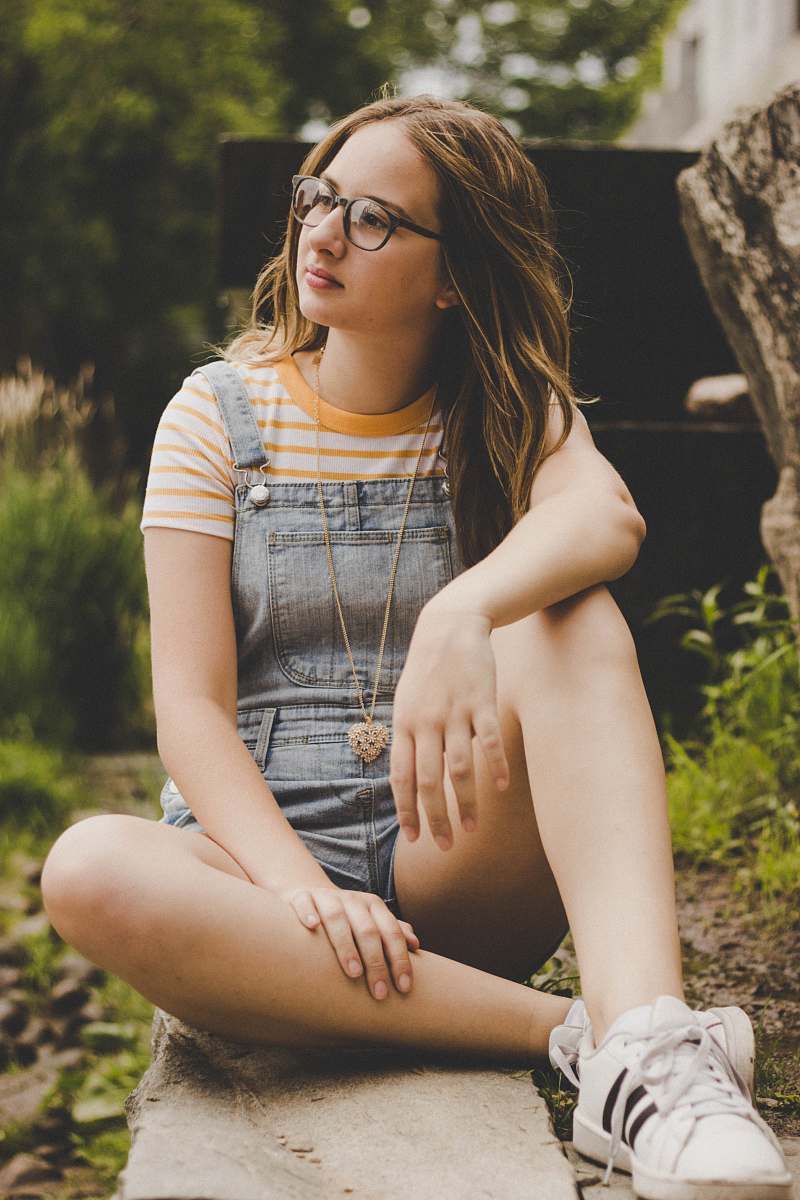 people woman sitting on concrete pavement person