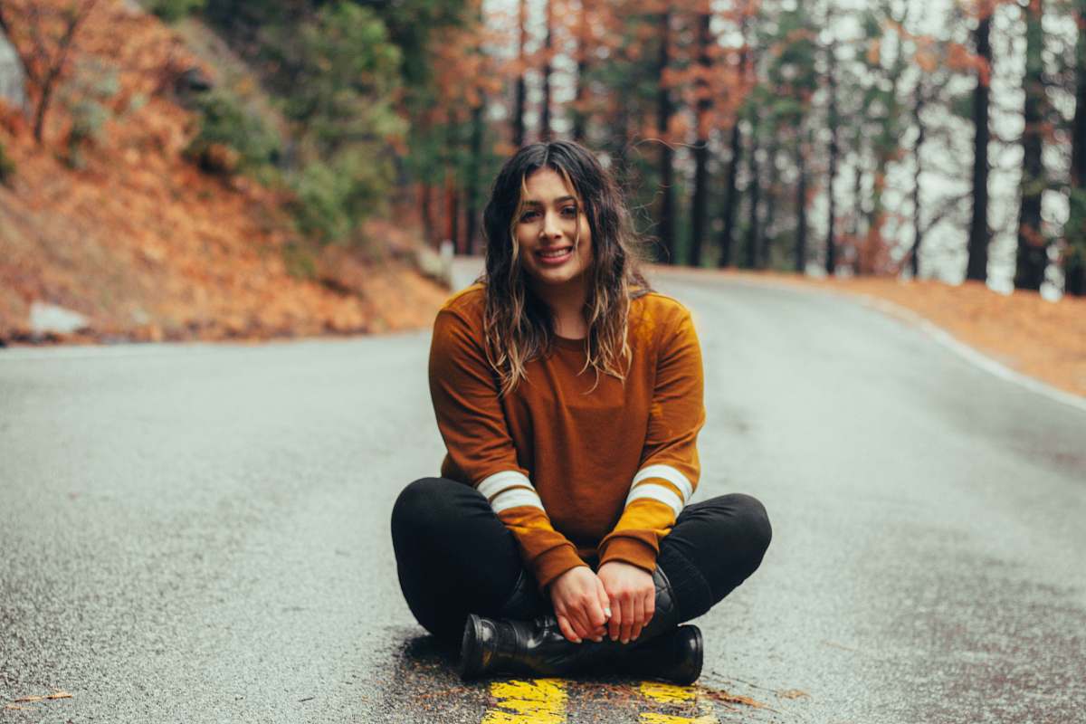 person woman sitting on concrete road people