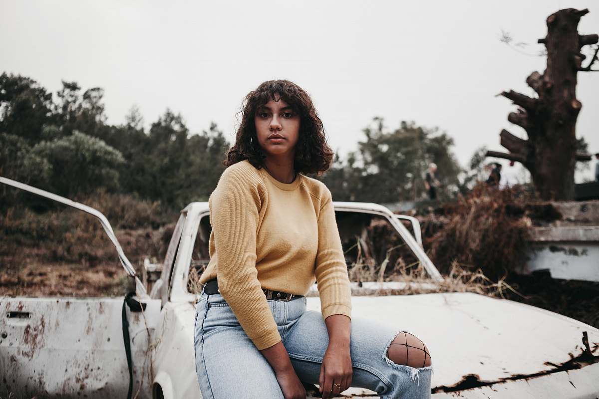 This captivating image features a woman sitting confidently atop a car, embodying a spirit of adventure and freedom. With her gaze directed towards the horizon, the scene captures a moment of reflection and tranquility. Perfect for projects related to travel, lifestyle, or automotive themes, this photograph evokes a sense of wanderlust and exploration, making it ideal for blogs, advertisements, or social media posts that celebrate the joy of the open road.