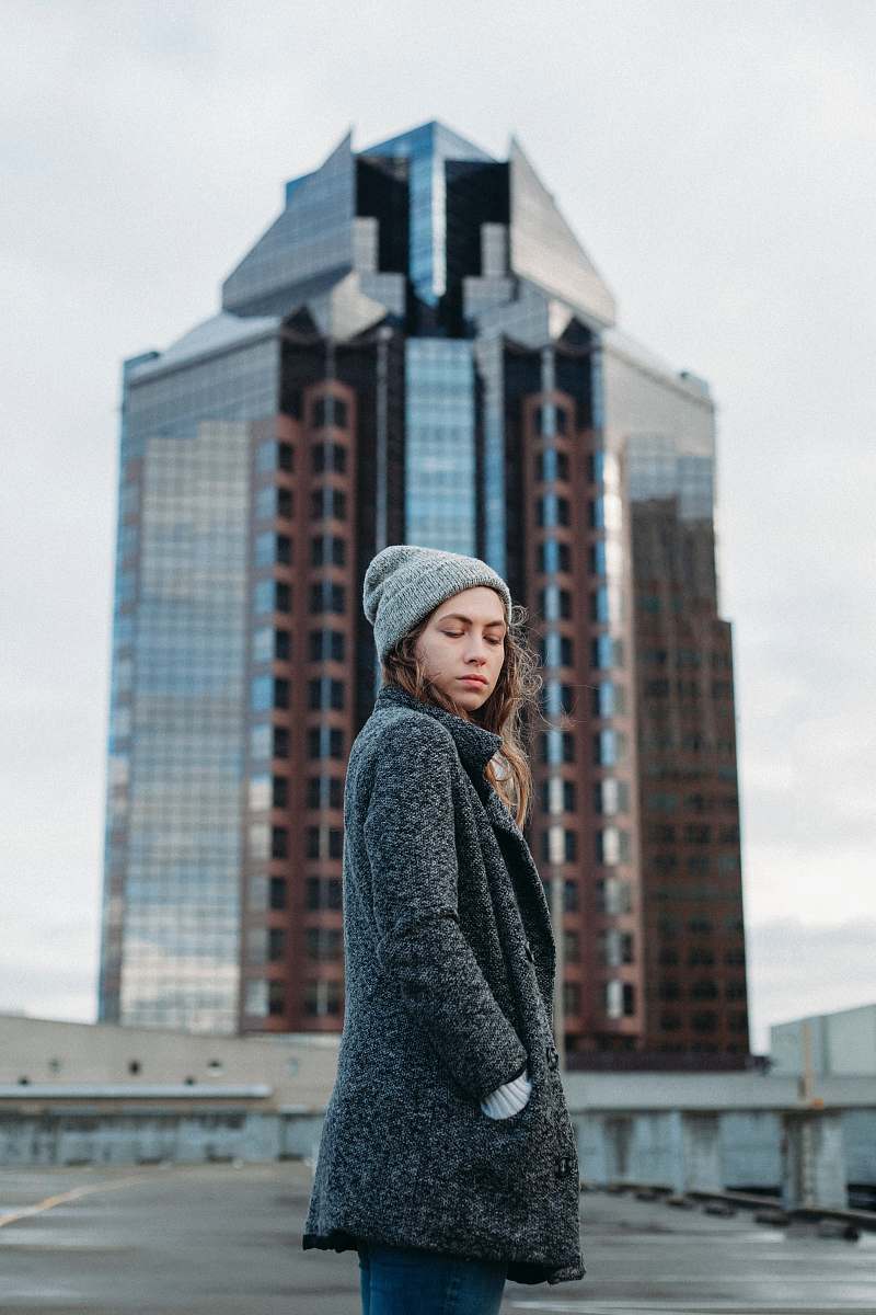 people woman standing behind high rise building during daytime person