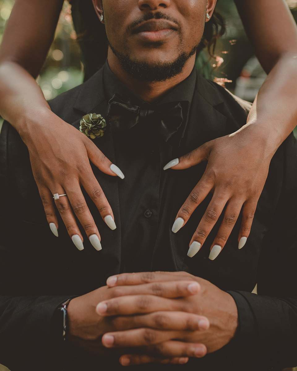 people woman standing behind man in black tuxedo person