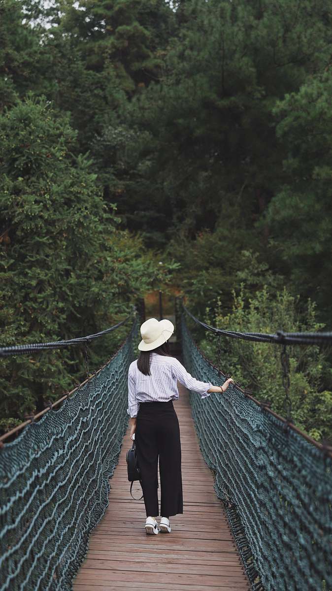 people woman standing in between brown and green bridge person