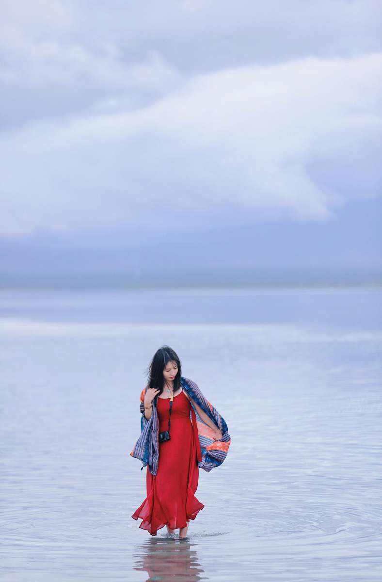 people woman standing in body of water at daytime person
