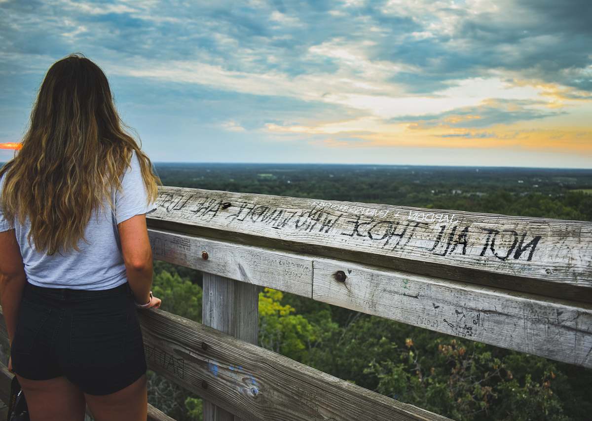 person woman standing in front of wooden fence people