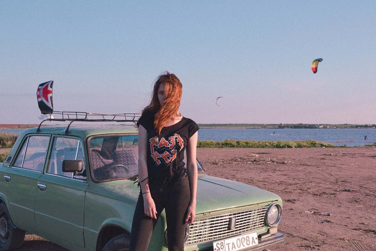 people woman standing near blue car on seashore car