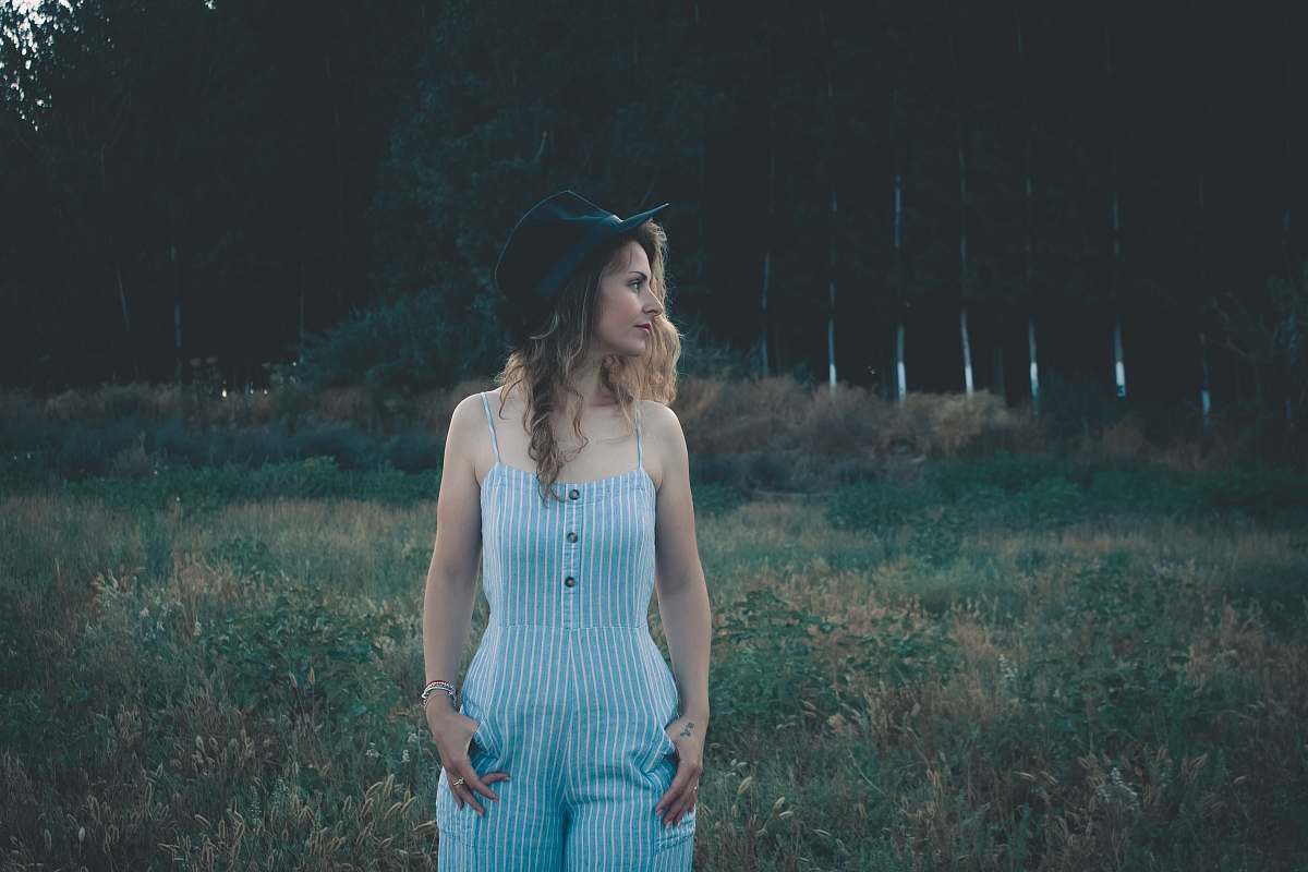people woman standing near green grass lawn during daytime showing her cheek person