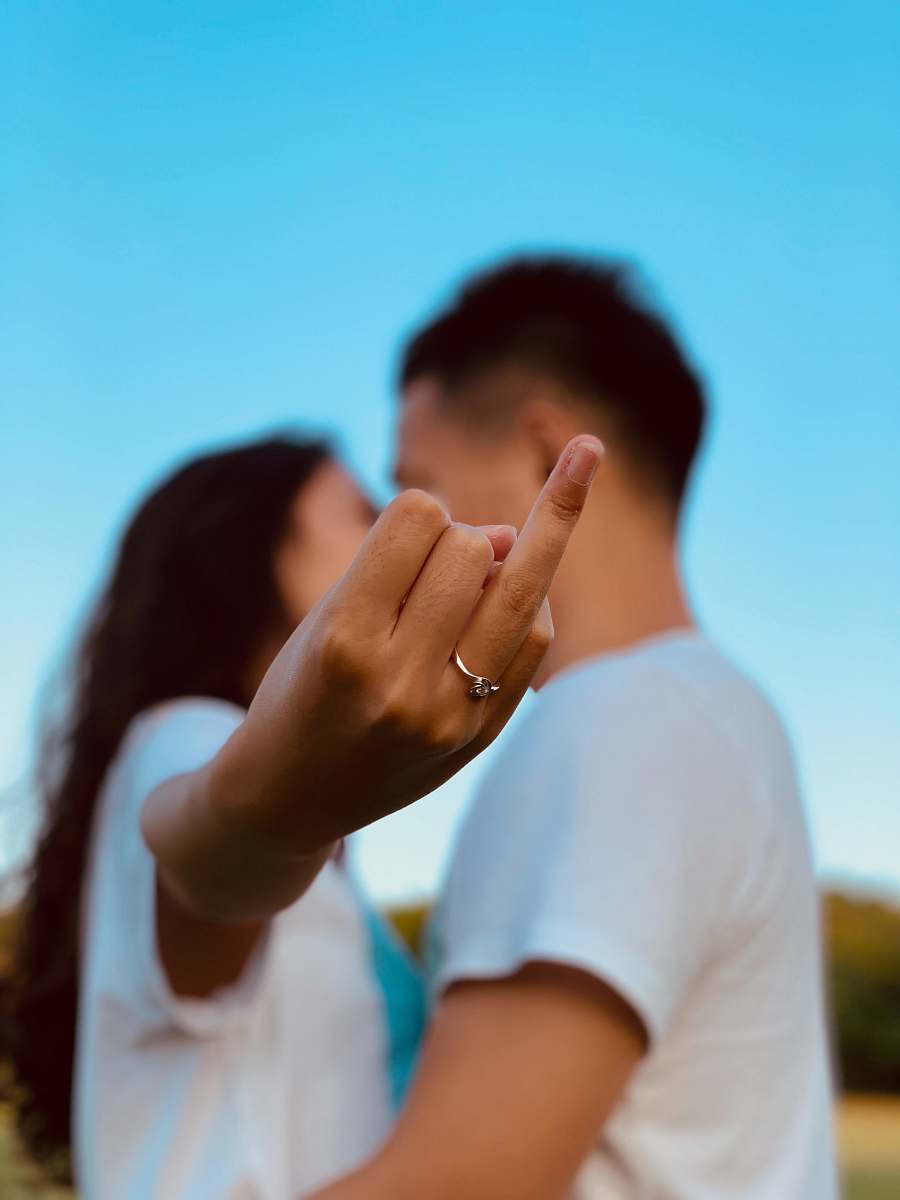 people woman standing near man making finger sign person