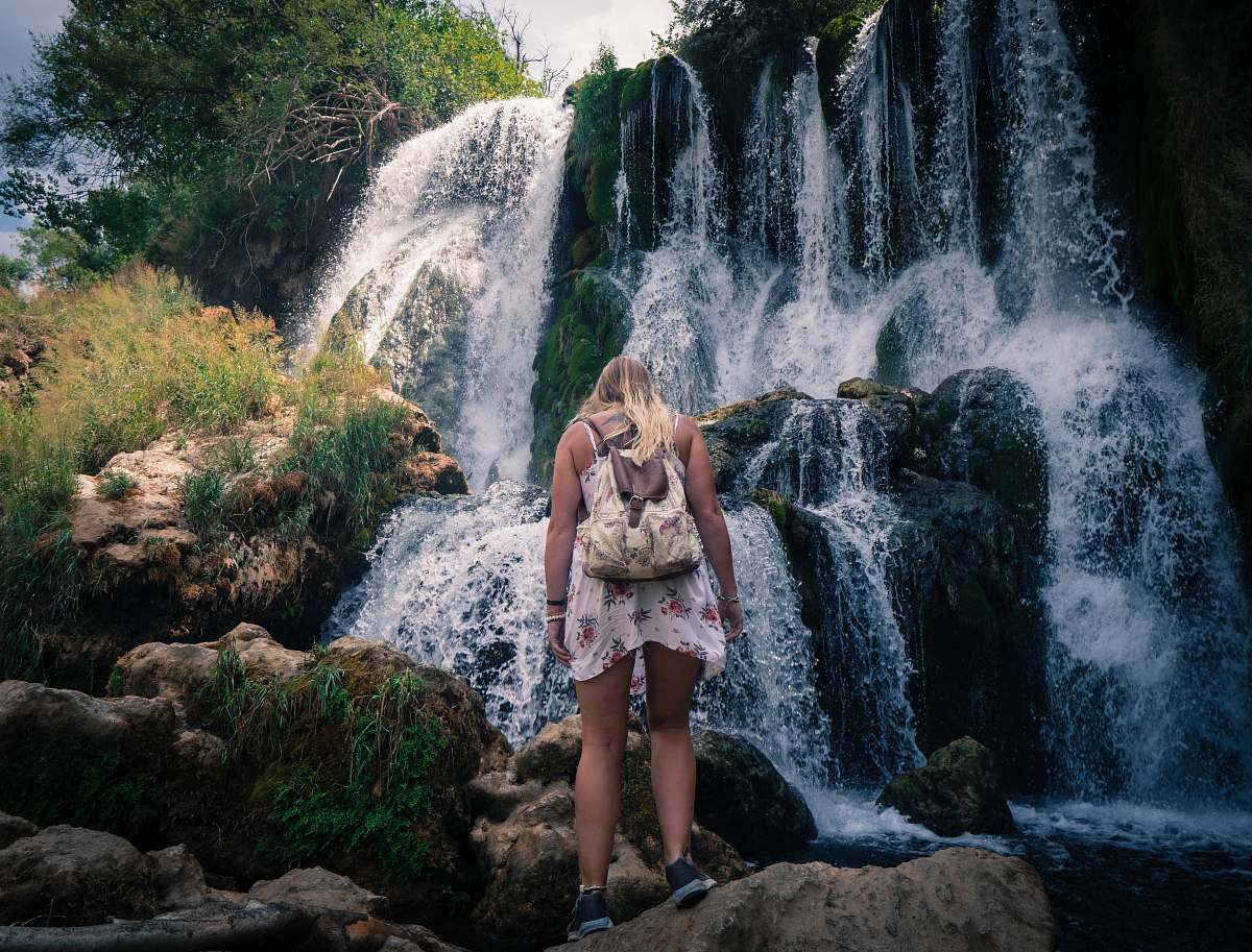 person woman standing near waterfalls people