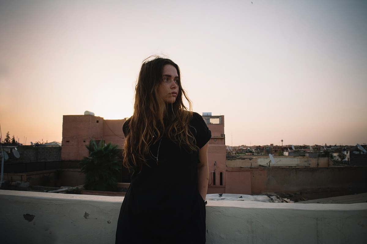 people woman standing near white concrete wall during daytime person