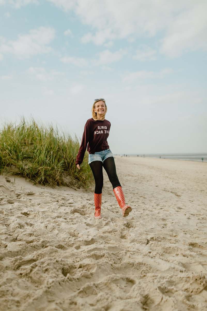 people woman standing on gray sand during daytime person