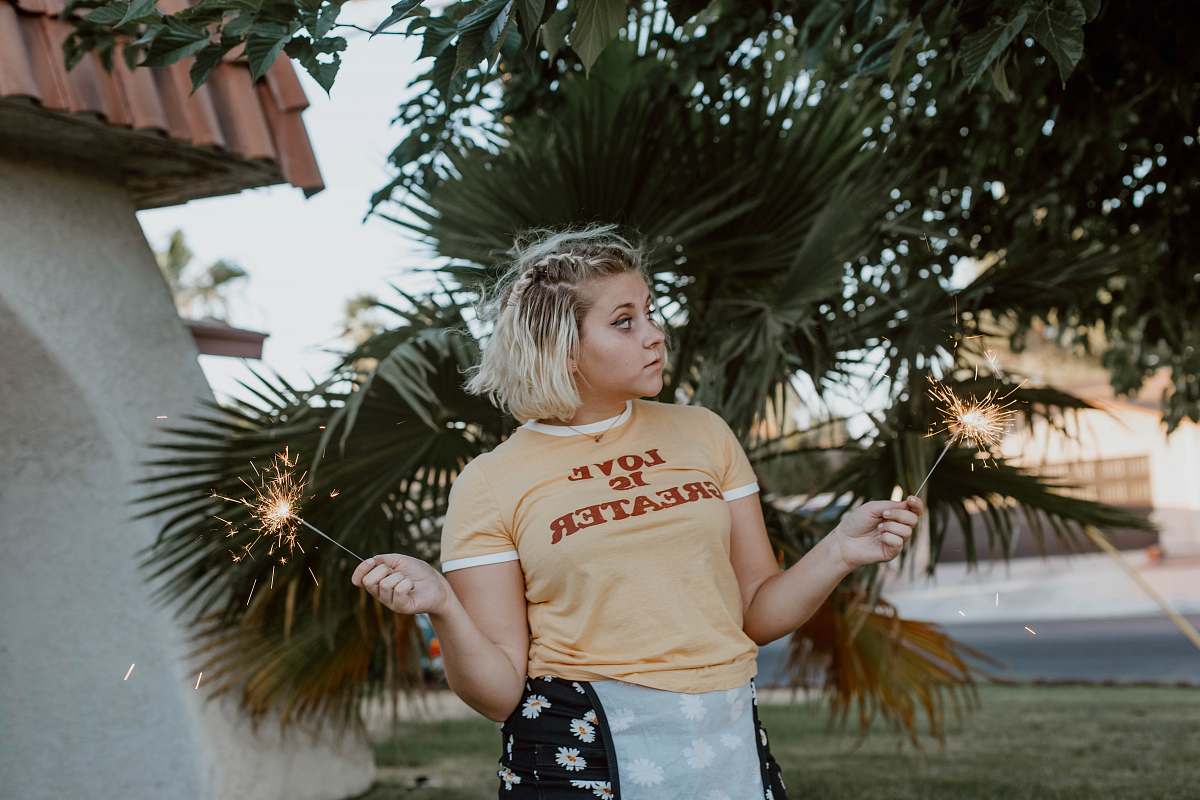 people woman standing while holding lighted sparklers person