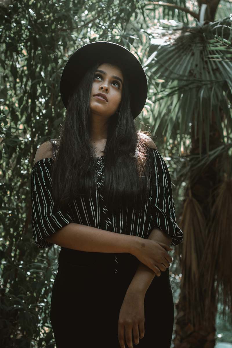 people woman standing with green plants behind at daytime person