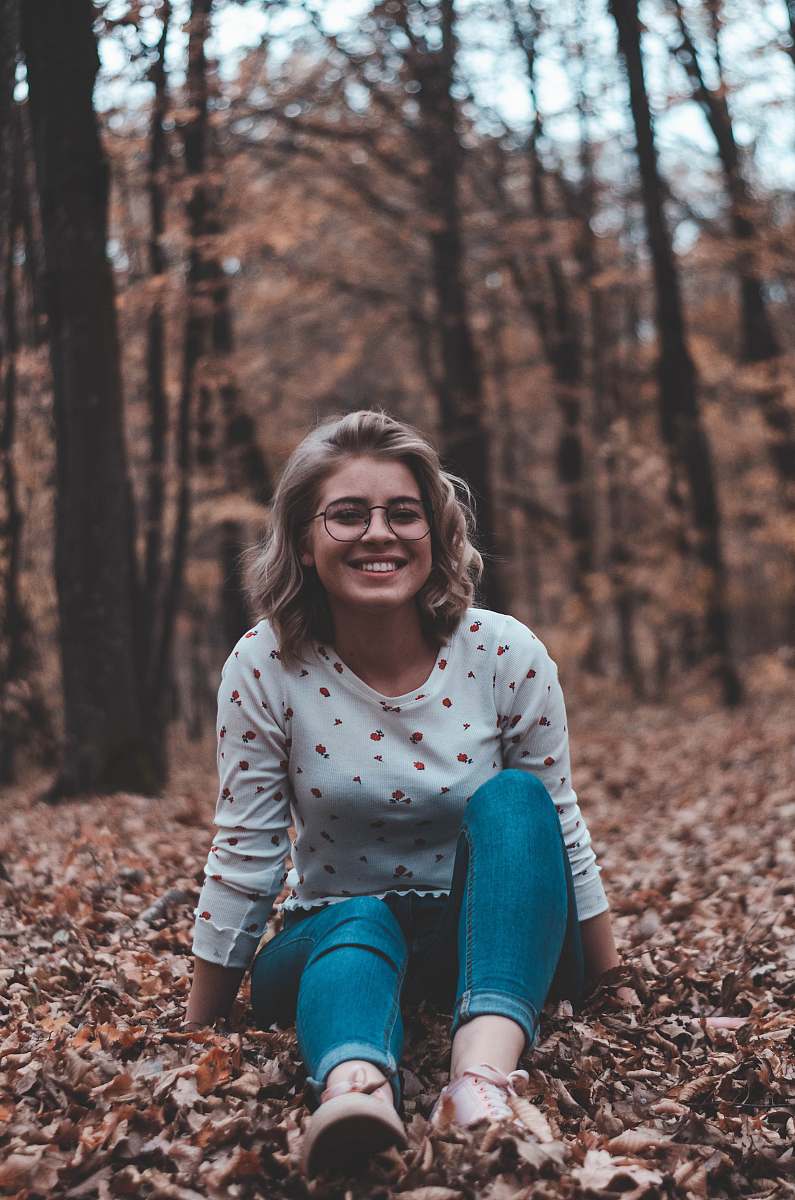 people woman surrounded by brown leafed trees person