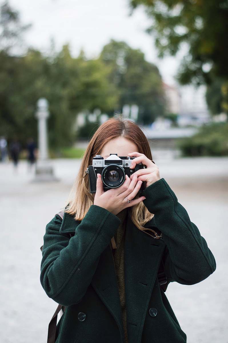 people woman using SLR camera near trees during day person