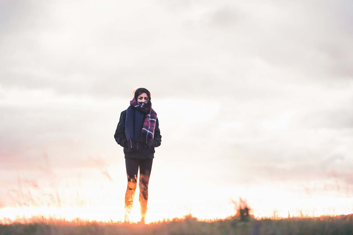 people woman walking on green grass under cloudy sky at daytime person