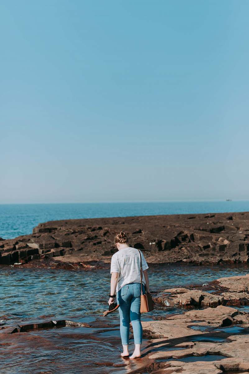 people woman walking on shore by the sea person