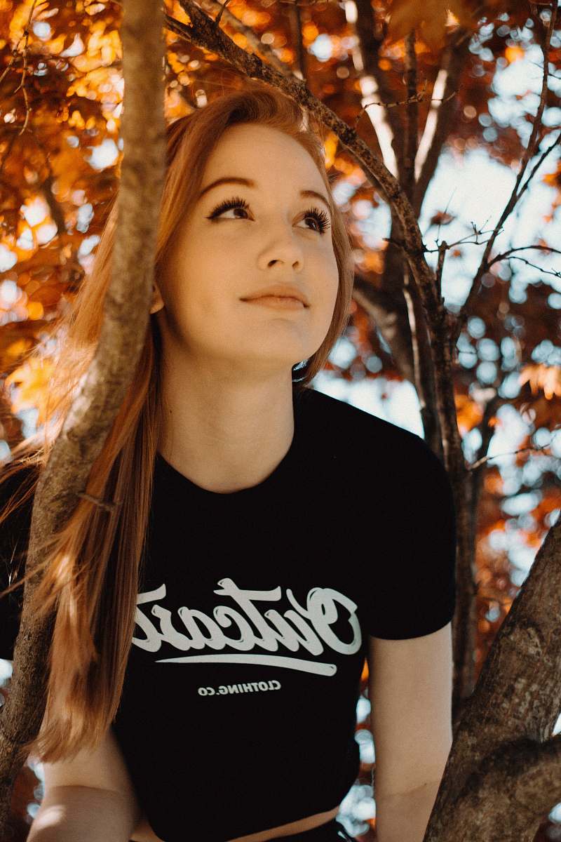 people woman wearing black crew-neck shirt sitting on tree person
