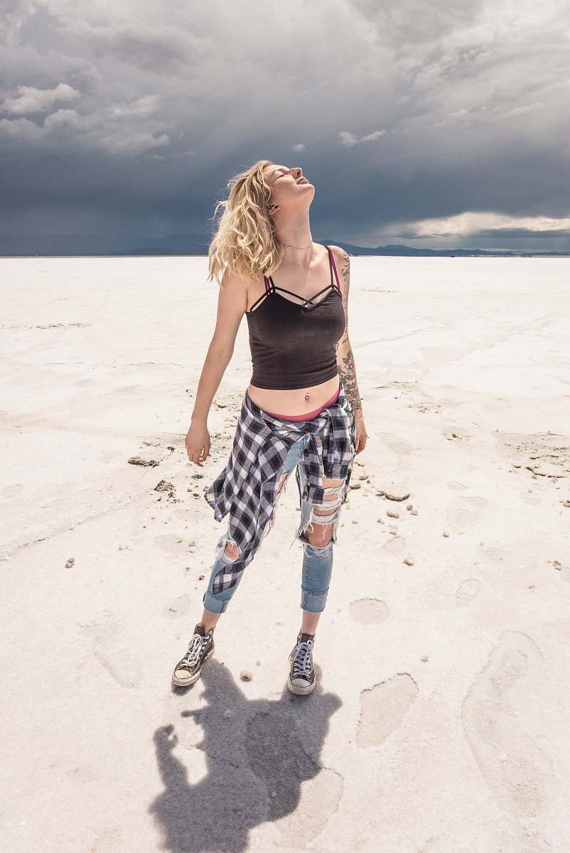 person woman wearing black crop top standing on desert people