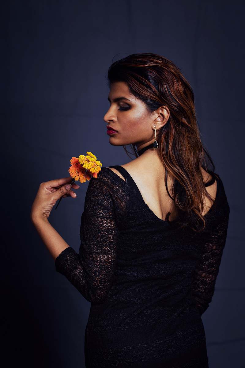 people woman wearing black long-sleeved dress holding flower person