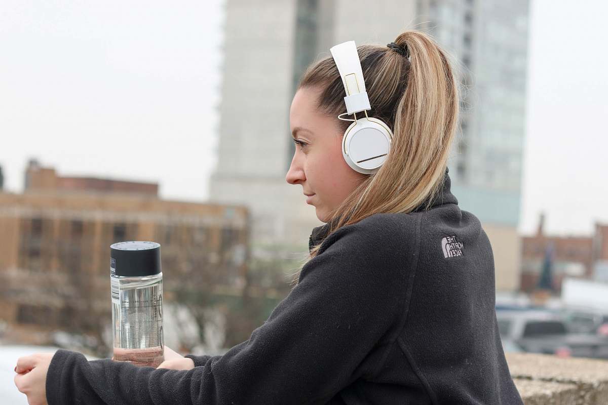 people woman wearing black The North Face jacket and white headphones person