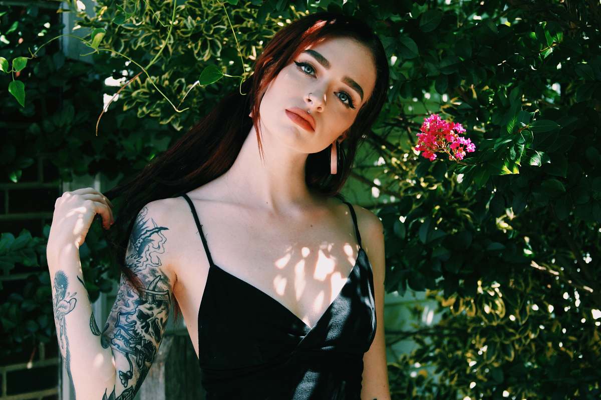 person woman wearing black top standing near flower people