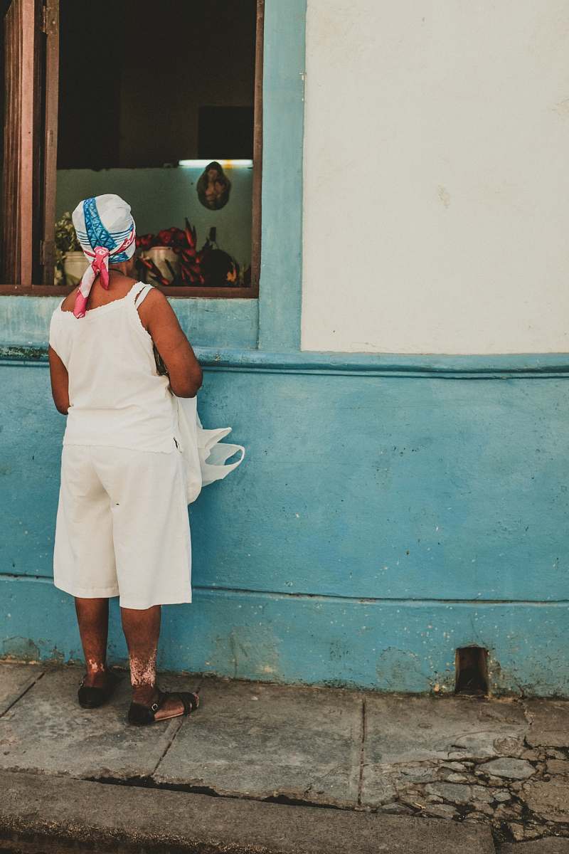 person woman wearing white camisole watching inside the window people