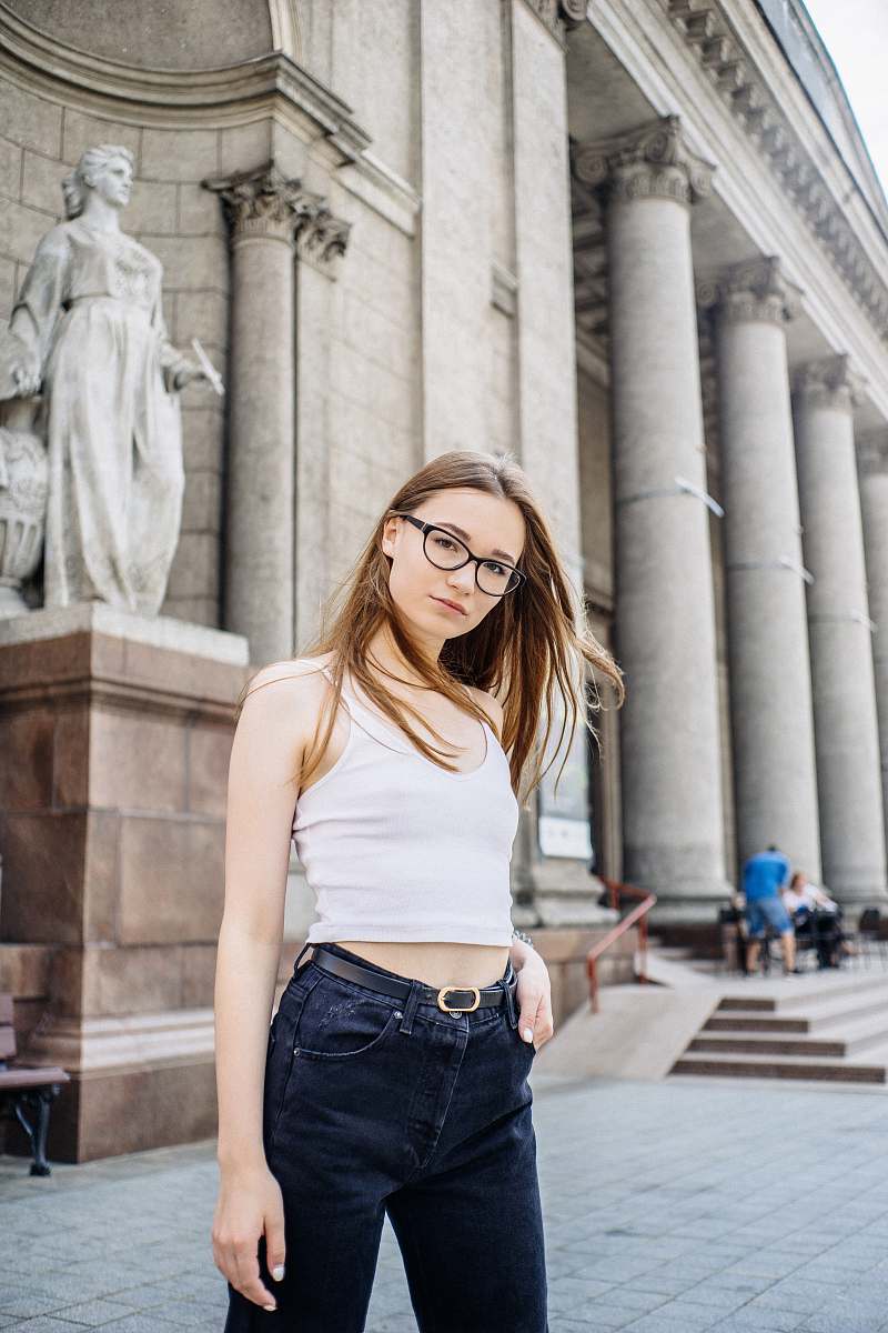 people woman wearing white tank top standing near statue person