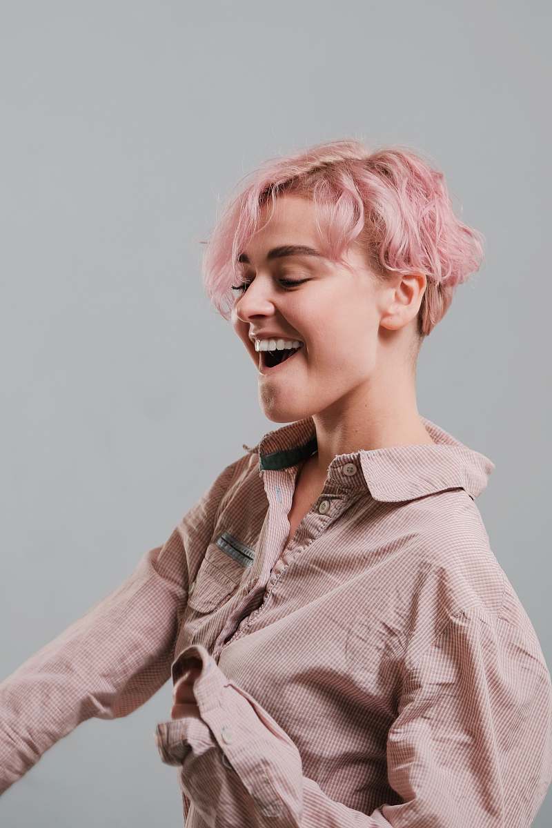person woman with pink short hair wearing beige dress shirt people