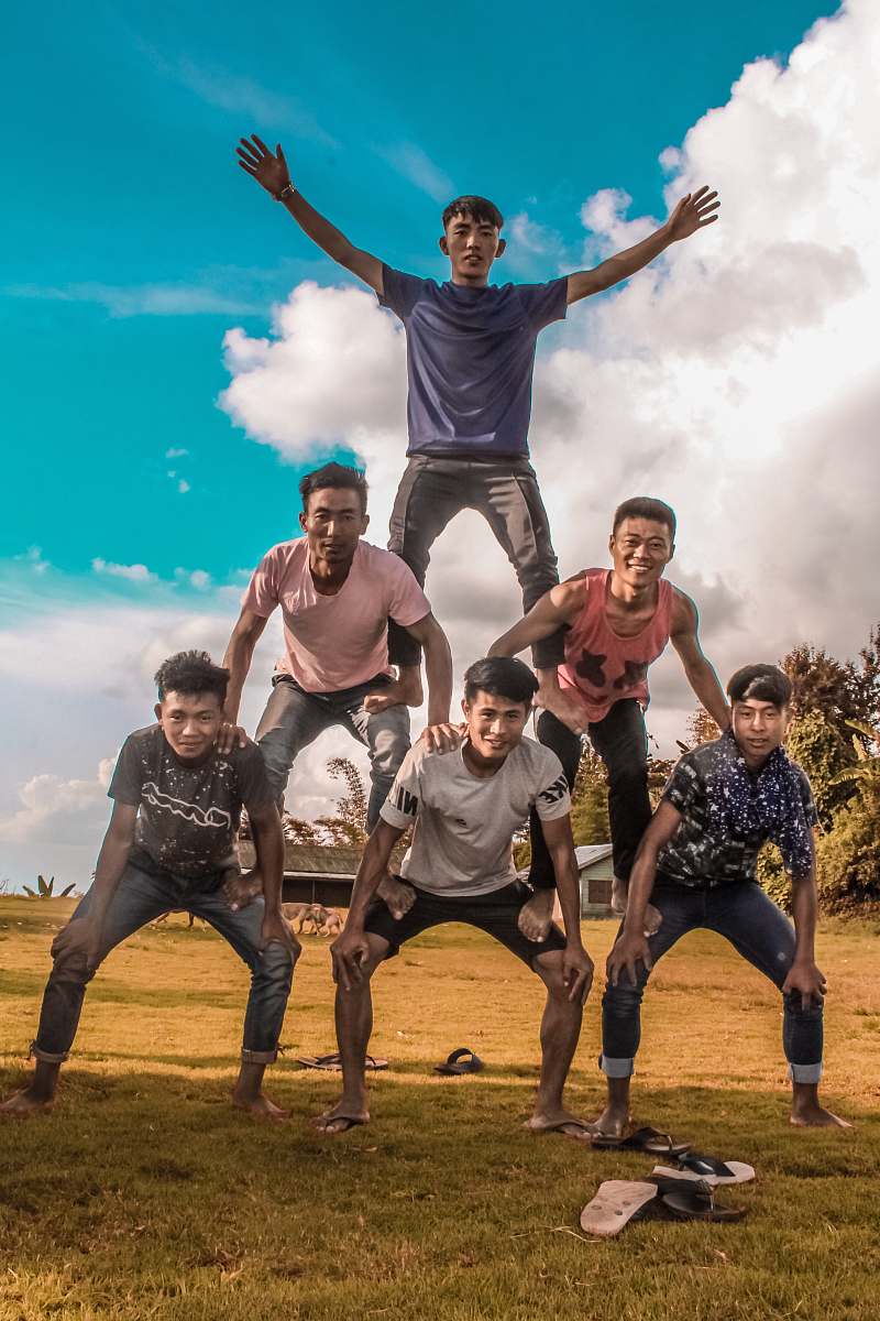 human 3-tier of men on grassy field person
