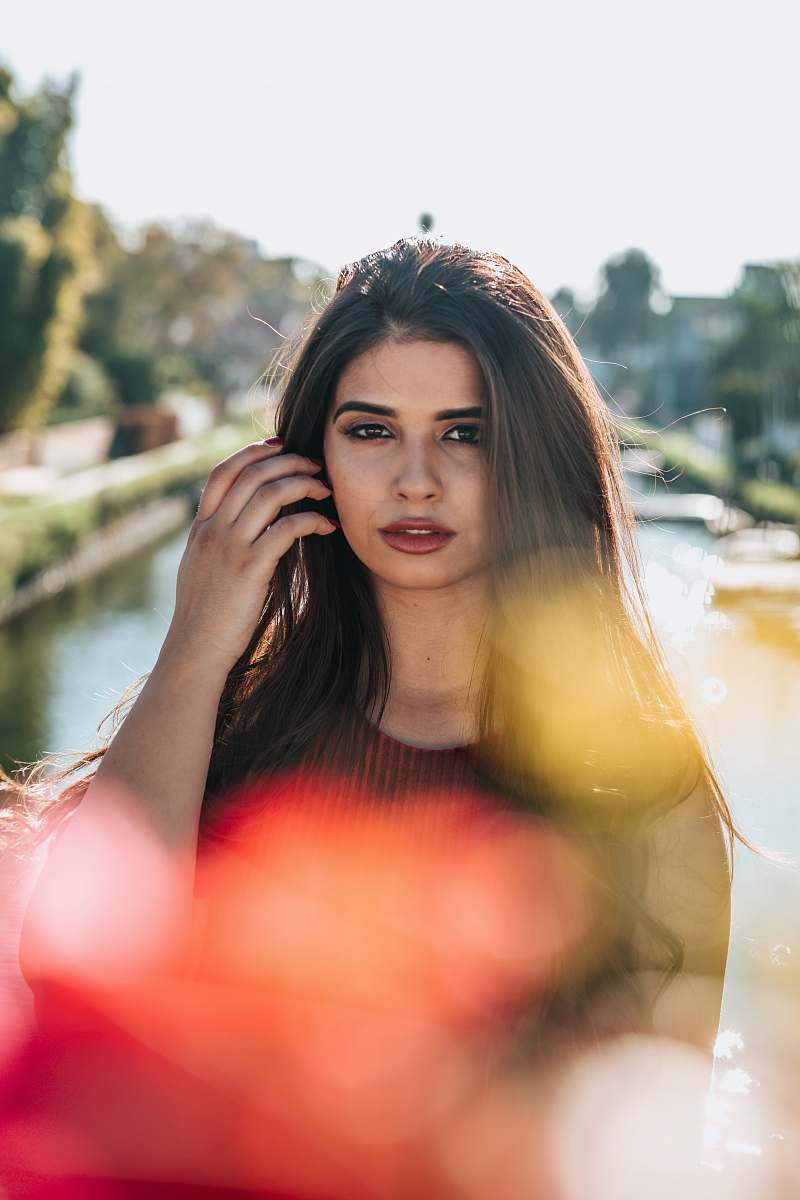 person bokeh photography of woman standing near body of water human