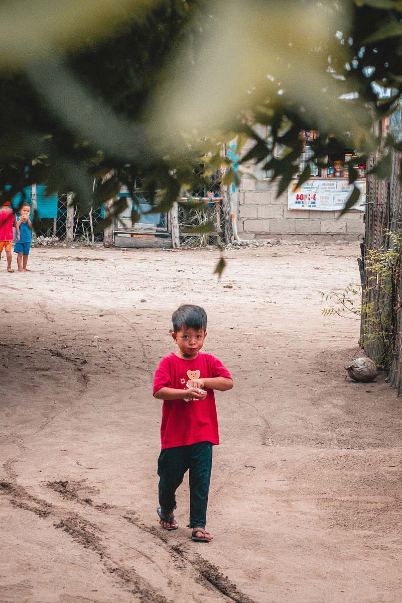 human boy in pink shirt walking on dirt person