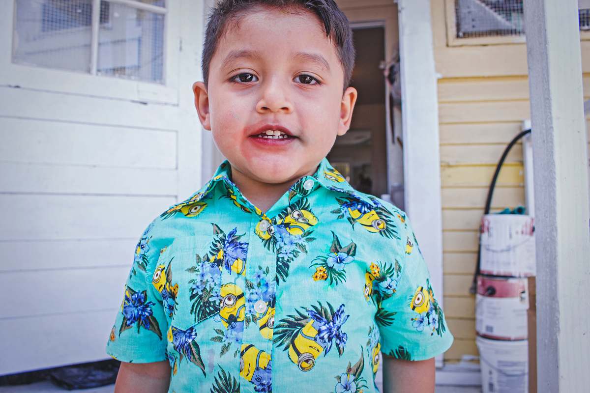 person boy wearing multicolored floral button-up shirt human