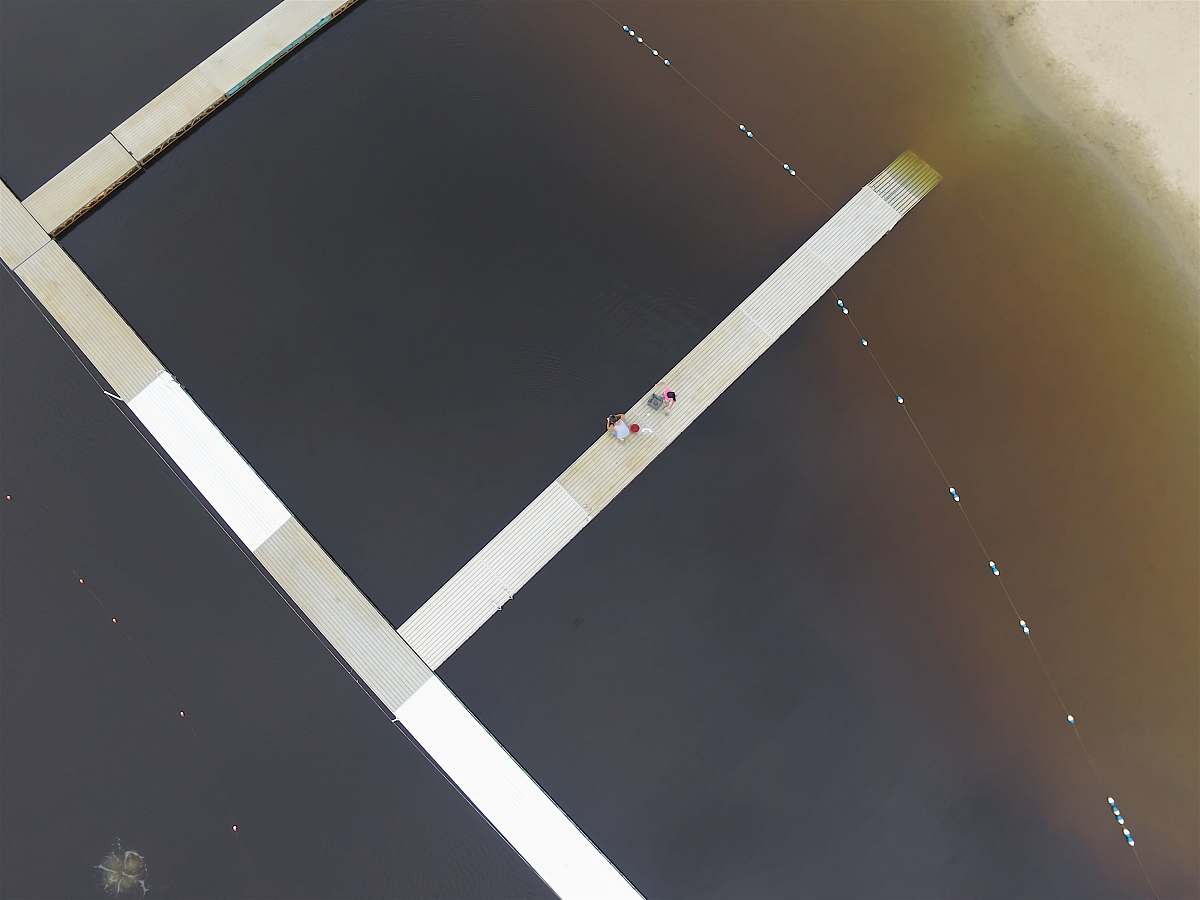 shore Drone view of people on the pontoon boardwalk beach dock at North Beach, Hale Reservation sand
