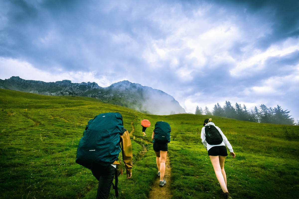 person four person hiking on mountain hill during daytime human