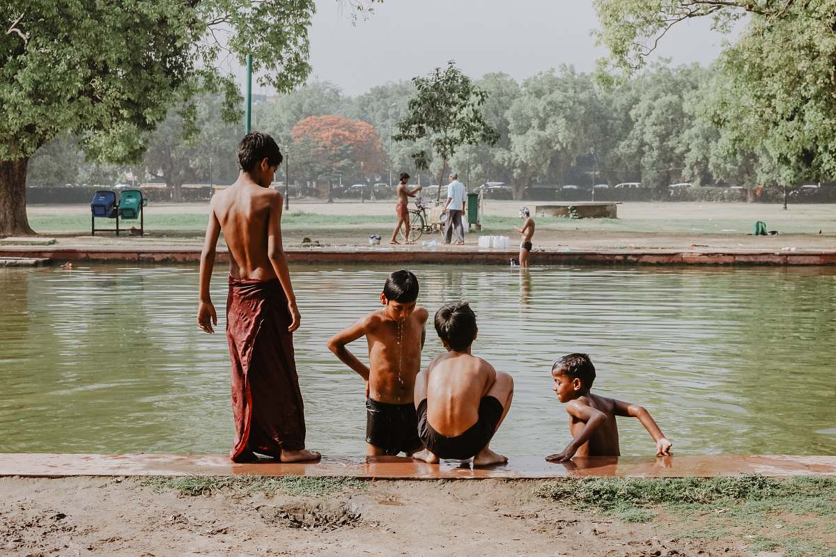 human four toddlers standing near body of water person
