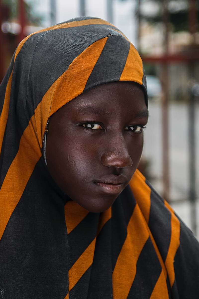human girl in black and orange striped head scarf in selective focus photography woman