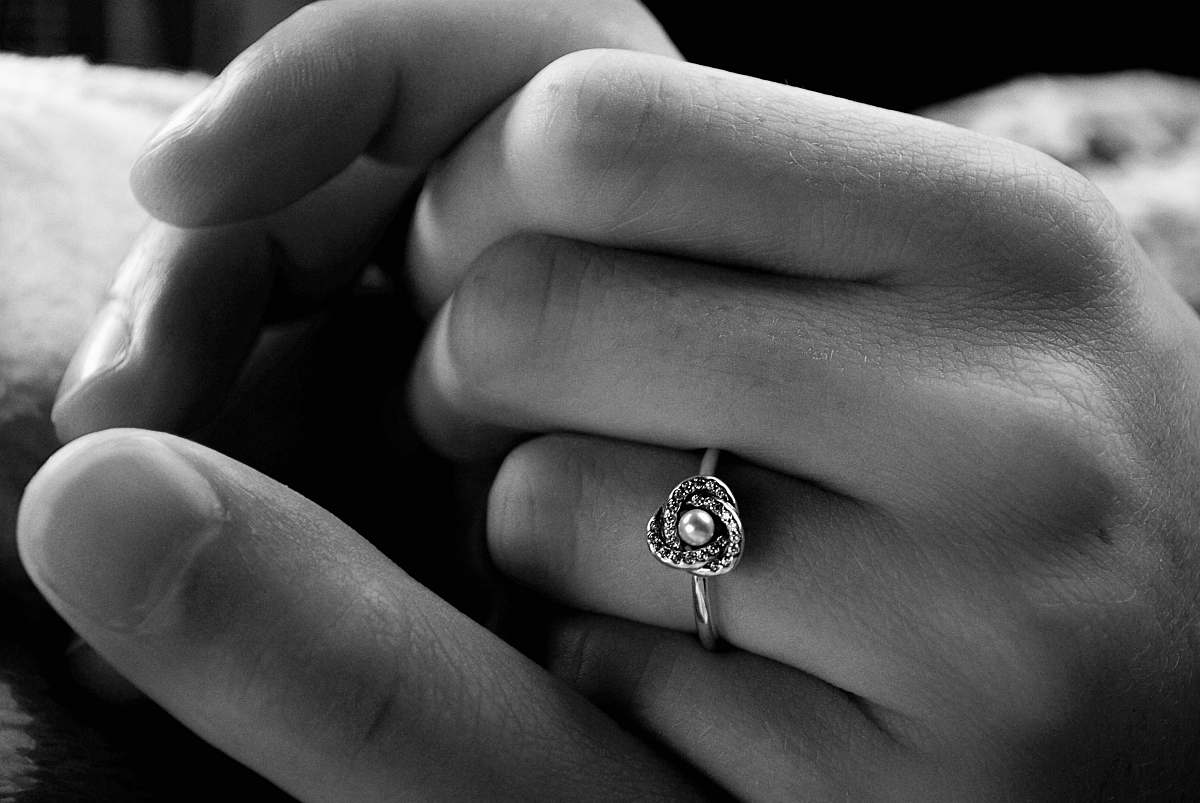 black-and-white grayscale photo of holding hands ring