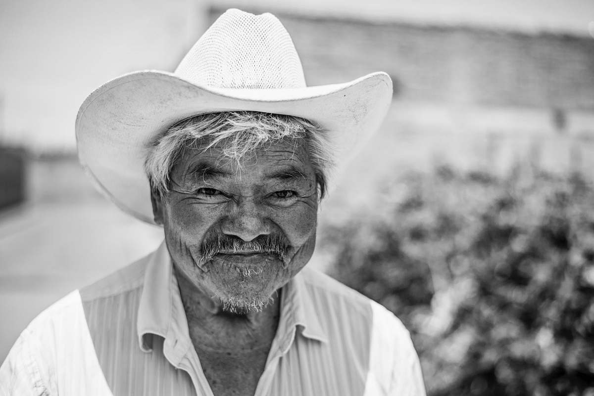 human grayscale photo of man wearing cowboy hat black-and-white
