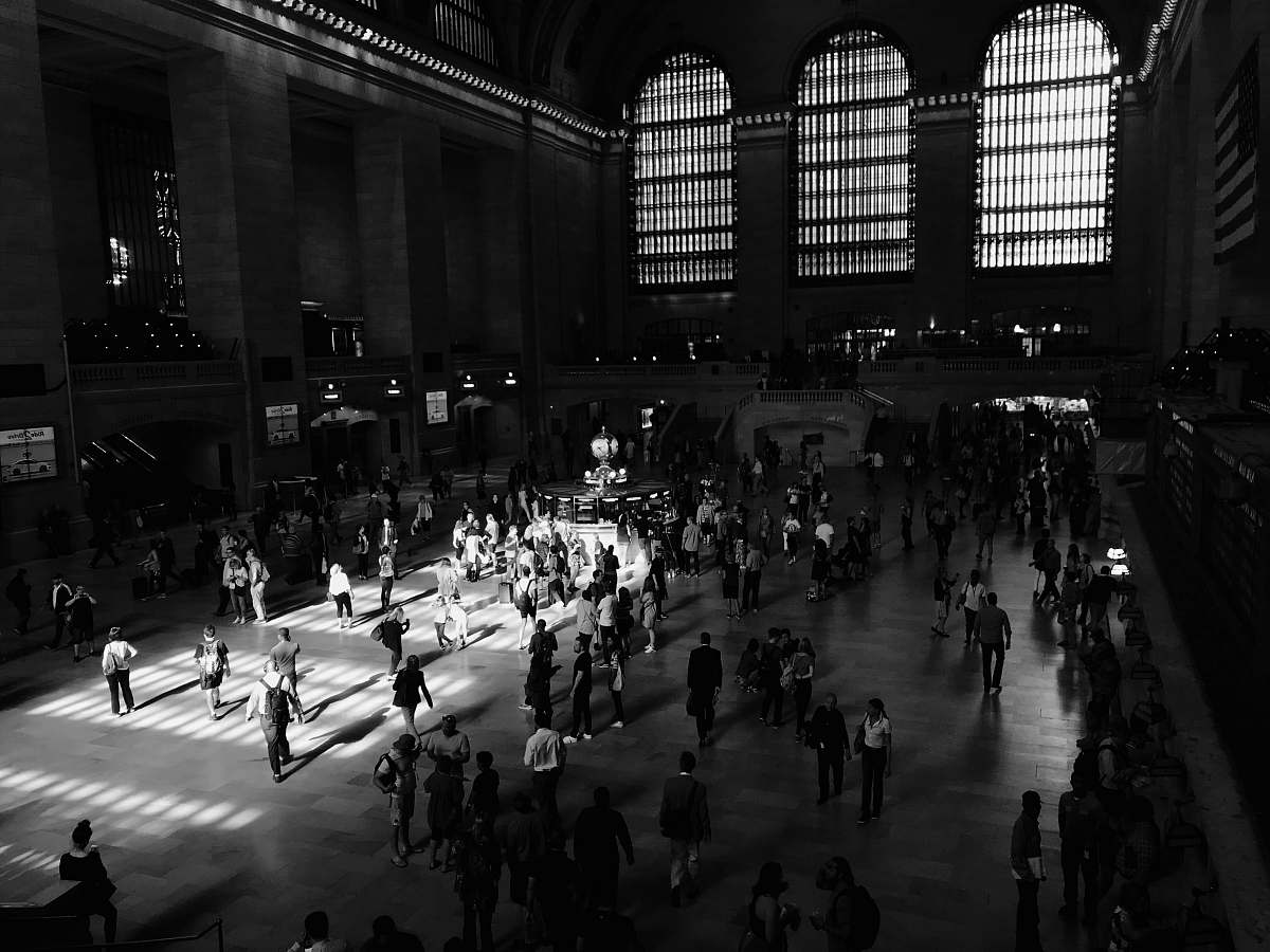 human grayscale photo of people walking inside the building black-and-white