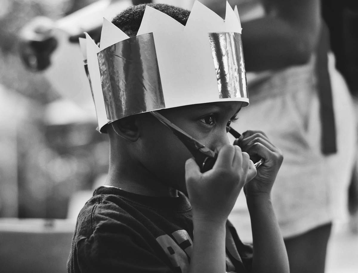 human grayscale photography of boy taking off sunglasses black-and-white