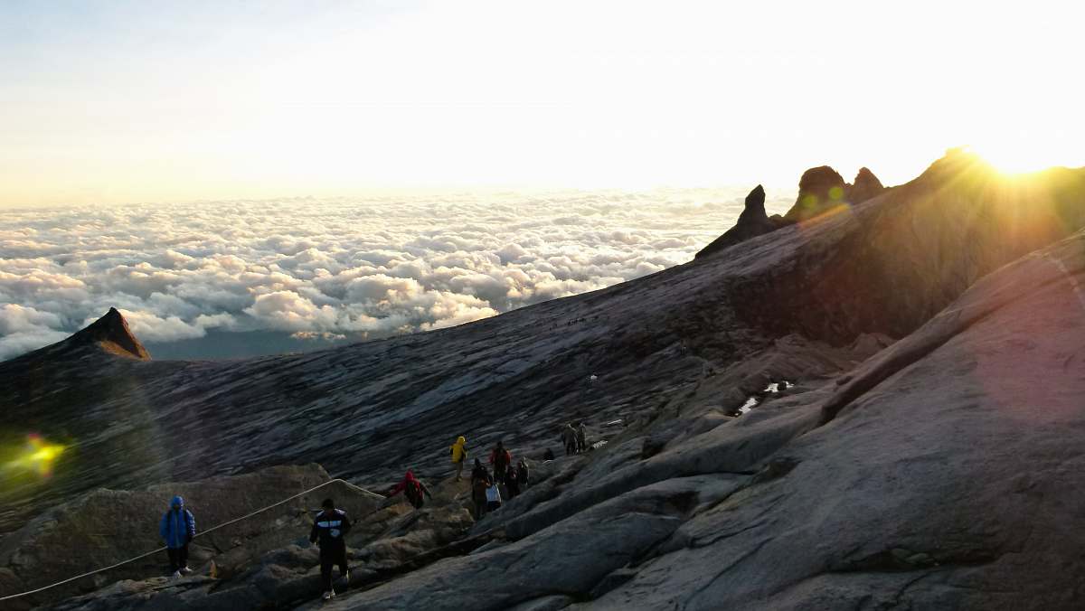 clouds landscape photo of people standing on mountain mountains