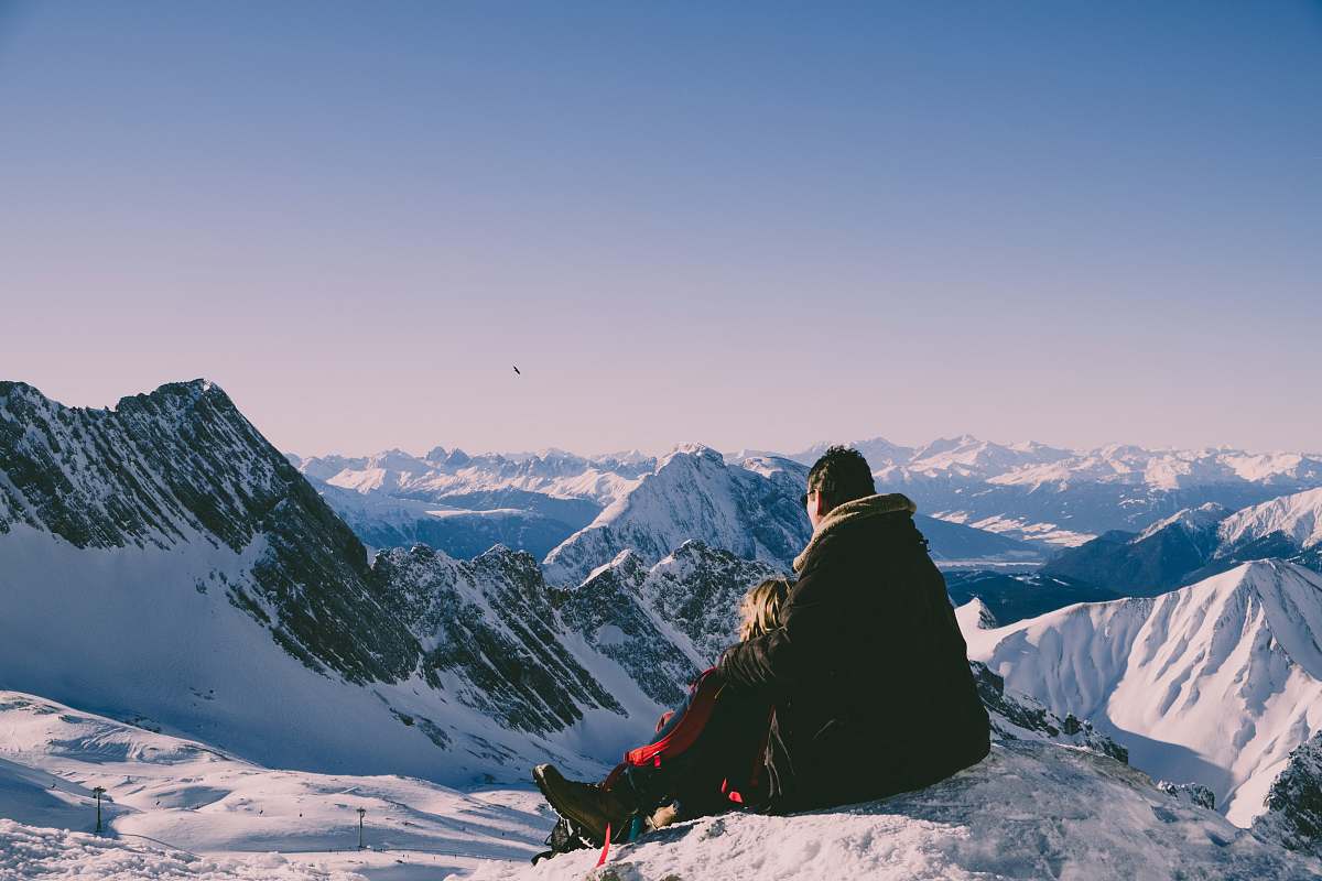 mountain man and woman on top of peak outdoors